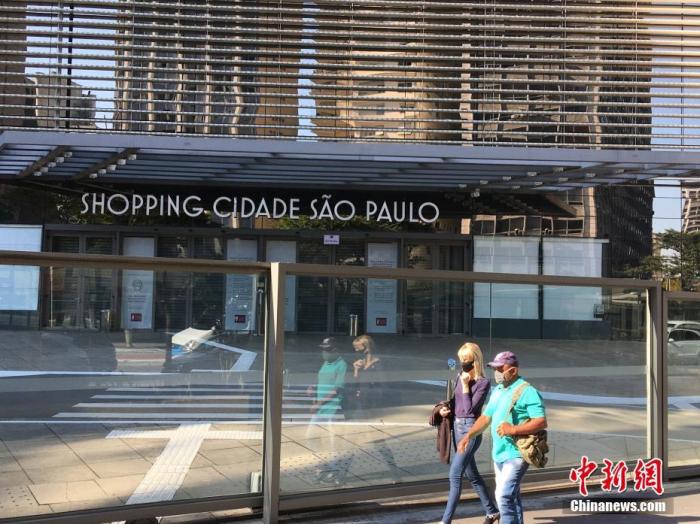 资料图：当地时间6月1日，在巴西圣保罗，两名行人从一家关闭的大型购物中心前走过。
/p中新社记者 莫成雄 摄